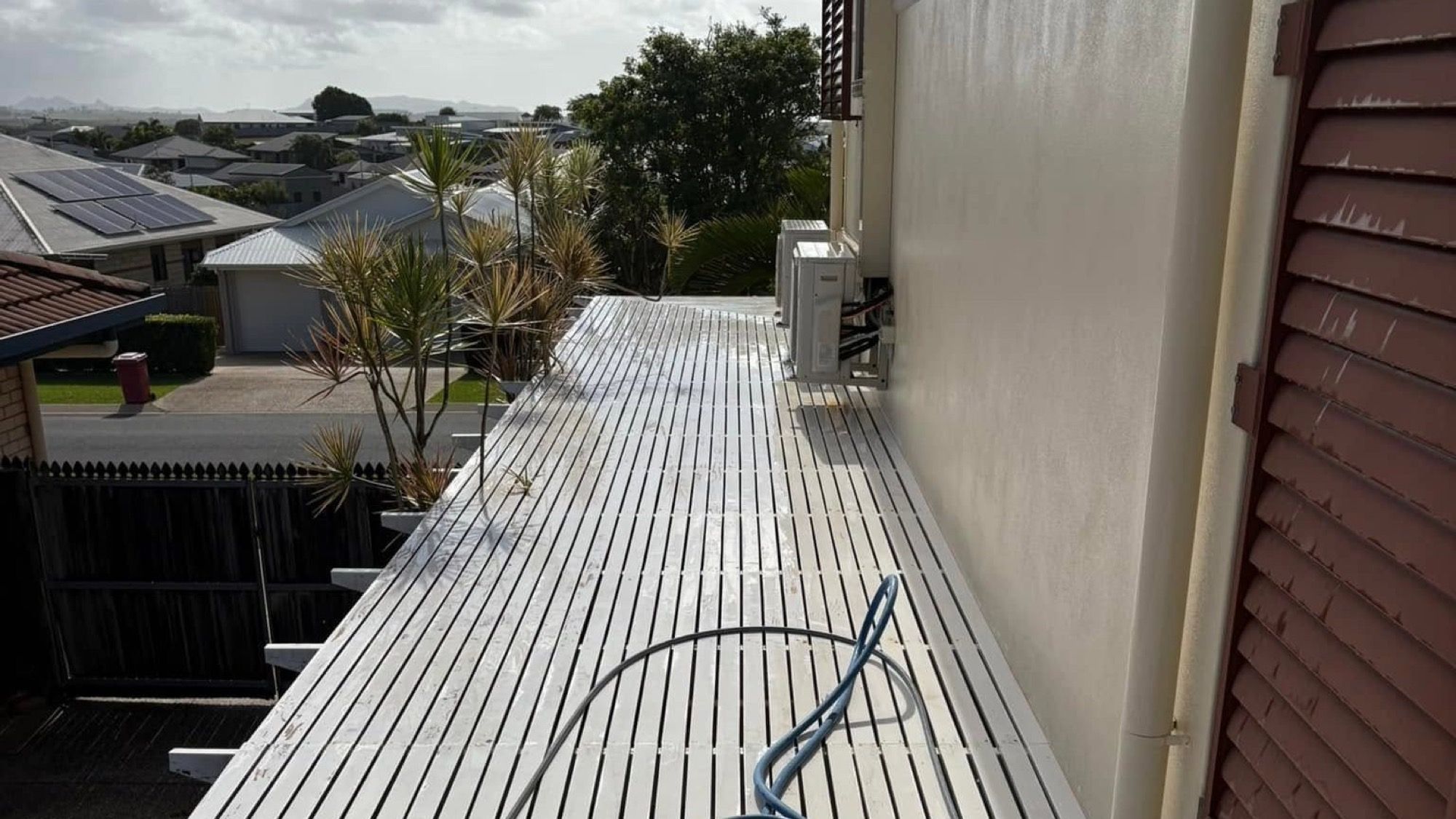 A long metal roof with a hose running along the length of it
