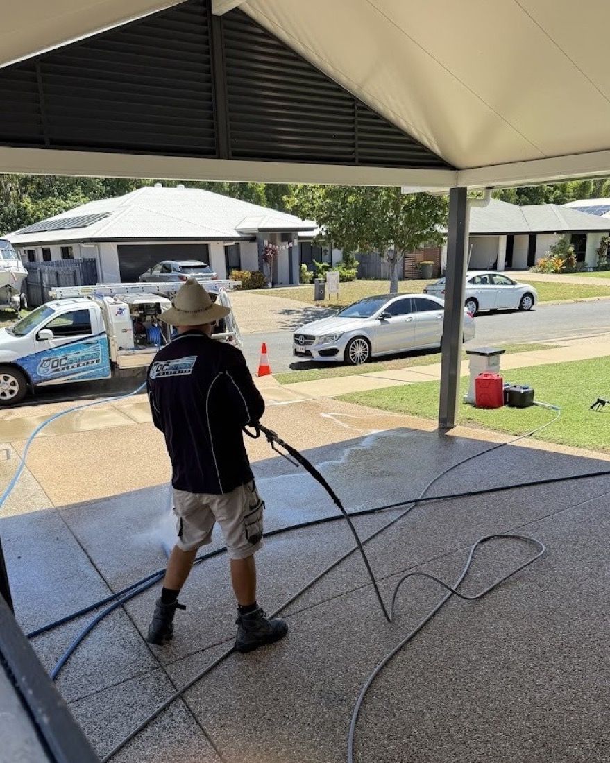 Dean pressure cleaning a driveway beside the DC Exterior Cleaning ute