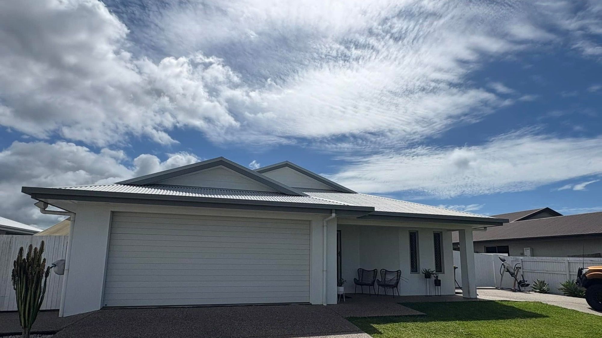 A lowset Mackay home with a wide driveway under a big cloudy sky