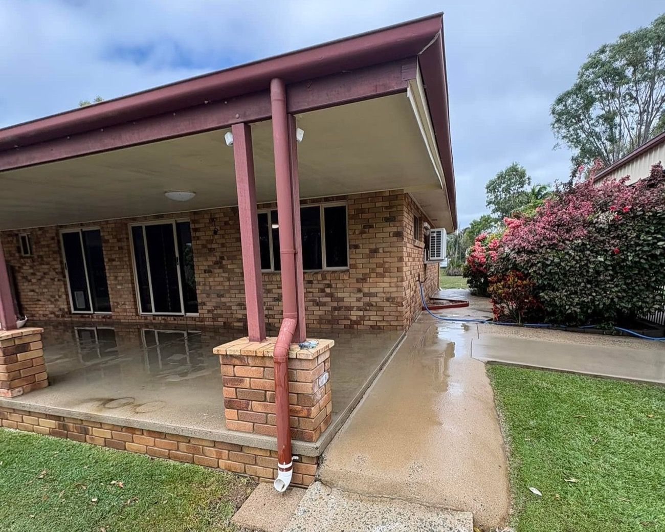 A brick and render home with a wet path around it