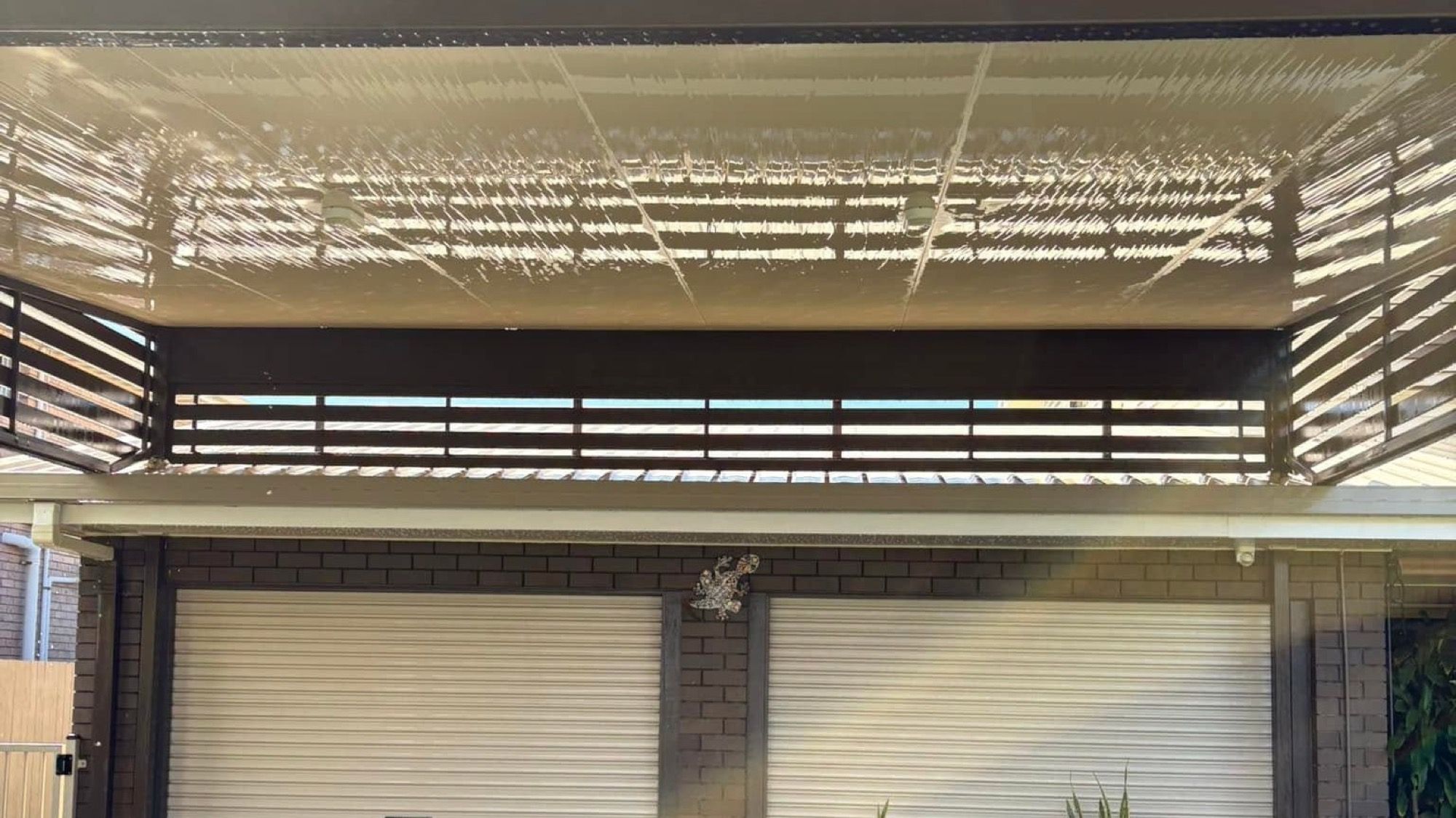A garage and driveway with a cleaning hose laid out across the concrete