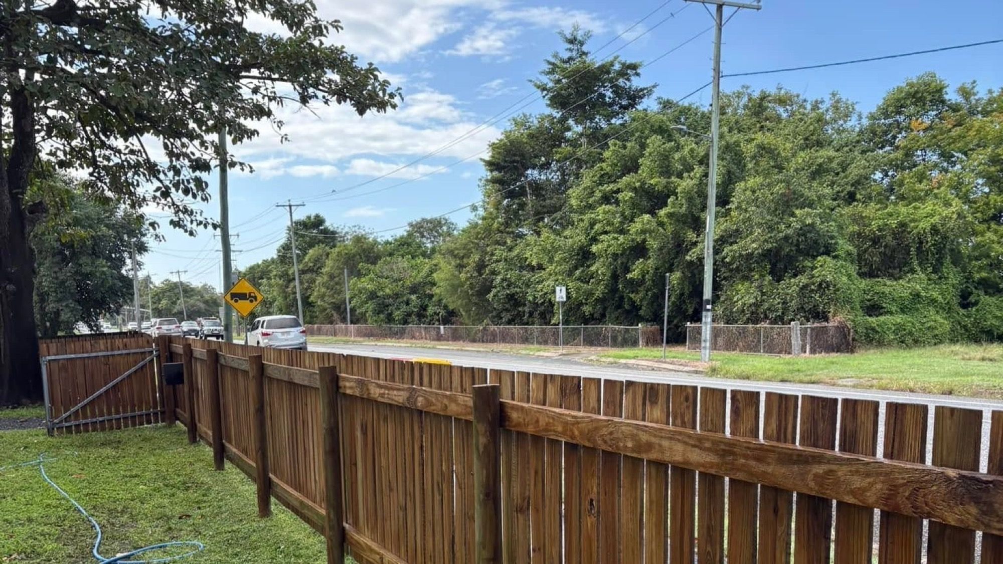 A timber boundary fence with water running down the palings