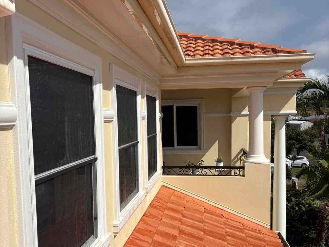A terracotta tiled roof beside a rendered wall