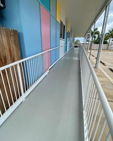 A long covered walkway running beside a carpark