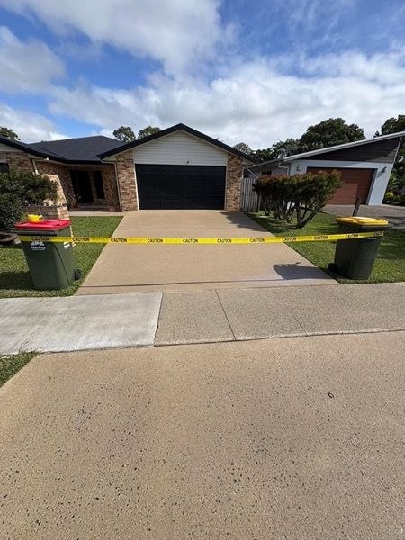 A brick home with a wide concrete driveway