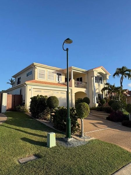 A two storey rendered home with palms in the front garden