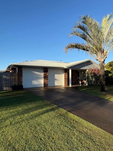 A lowset brick home with a palm tree in the front yard