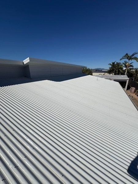 A pale metal roof under a clear sky