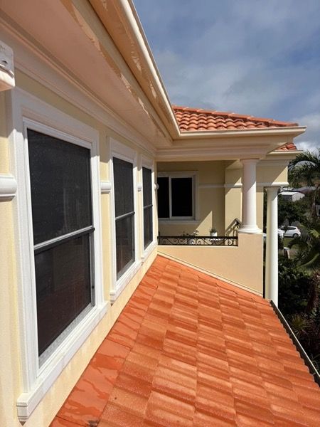 A terracotta tiled roof beside a rendered wall