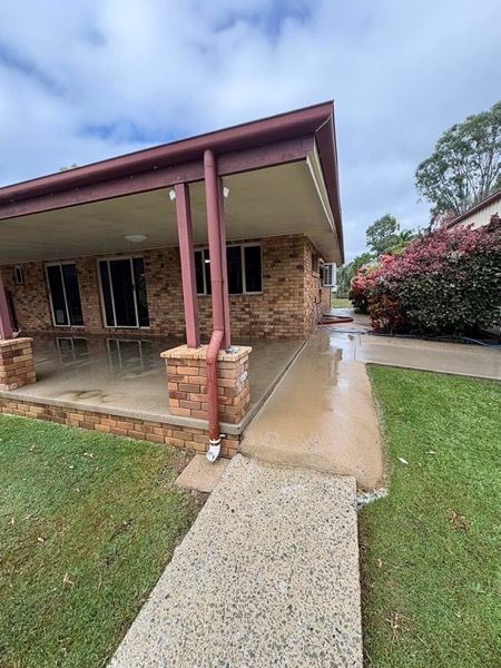 A brick and render home with a wet path around it