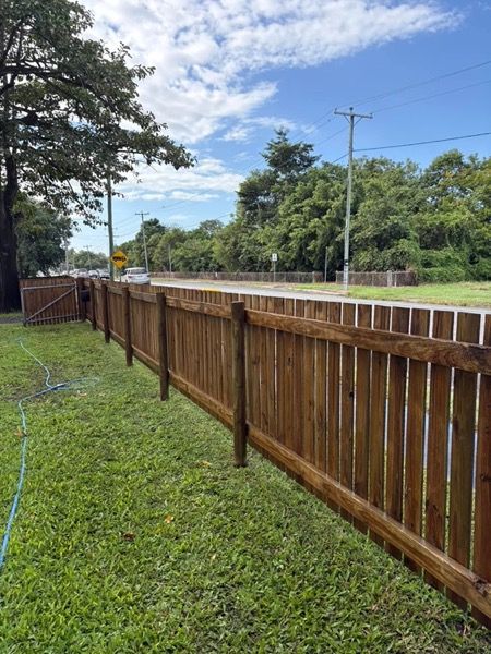 A timber boundary fence with water running down the palings