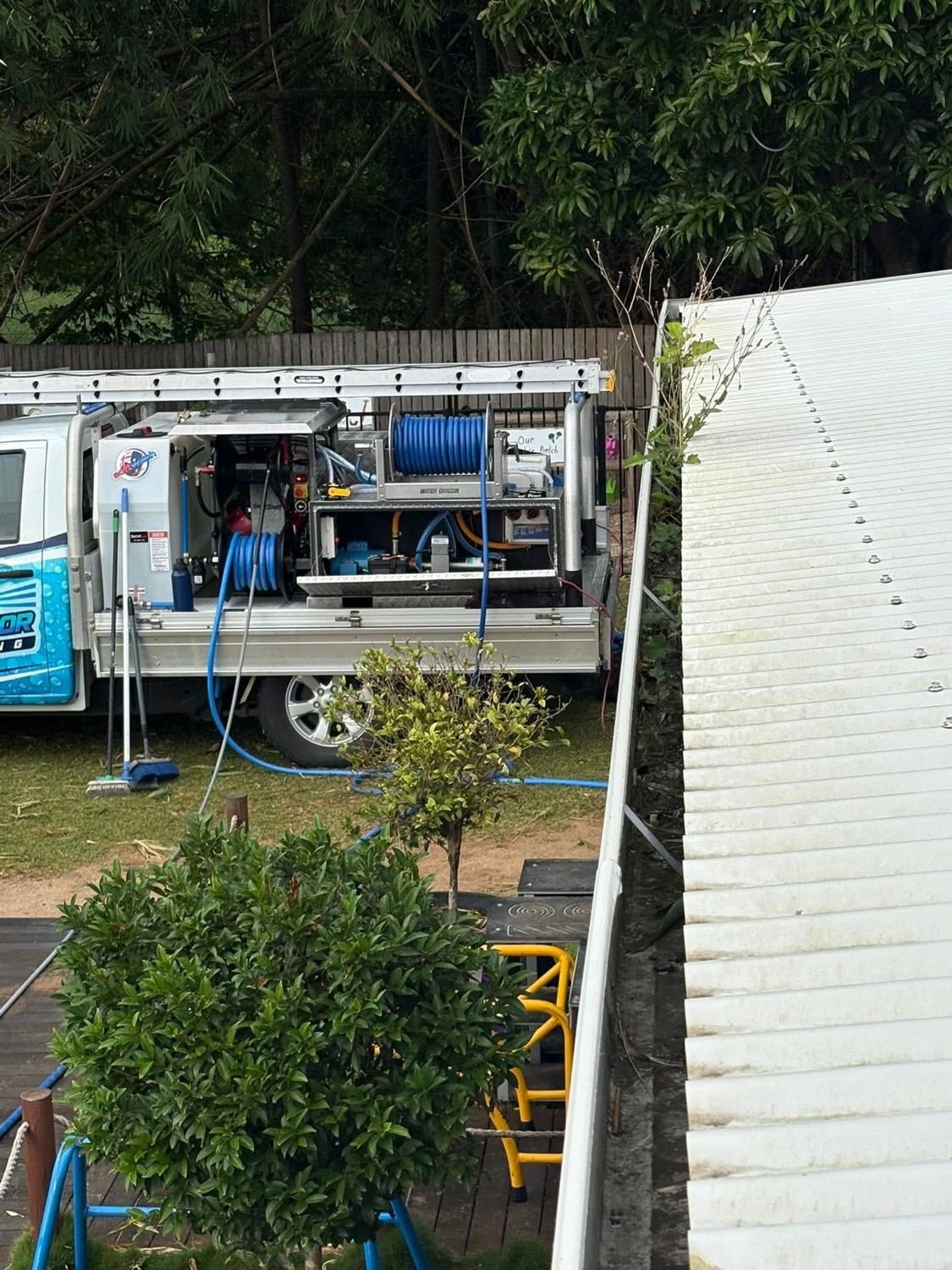 A pressure cleaning rig on a ute tray parked beside a Mackay house